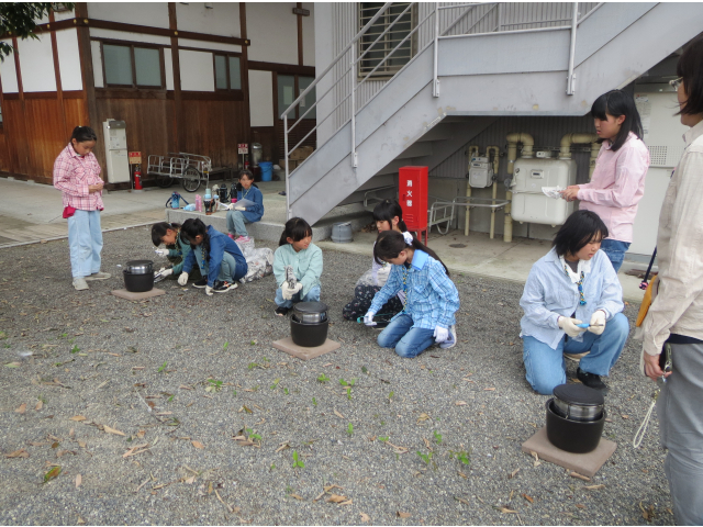 タイムキーパーの指示に従い、かまどに燃料をくべます