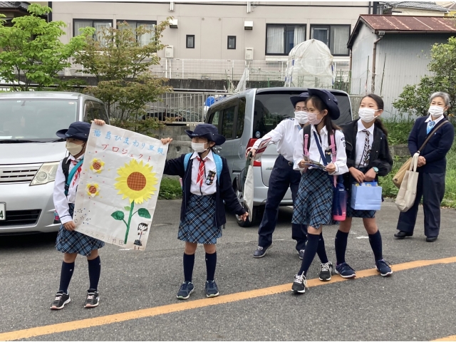 地元の人たちにひまわりの種を配ります。